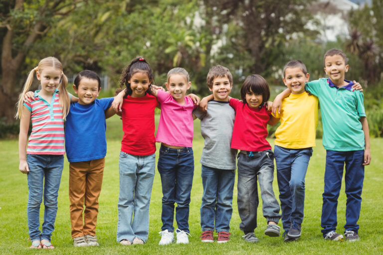 Cute pupils smiling at camera outside on elementary school campus