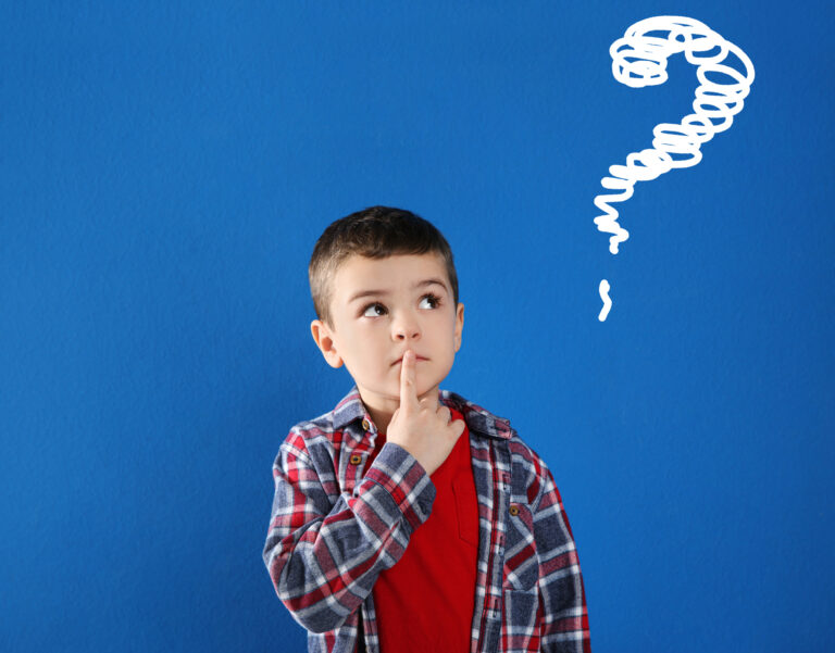 Thoughtful little boy in casual outfit on blue background